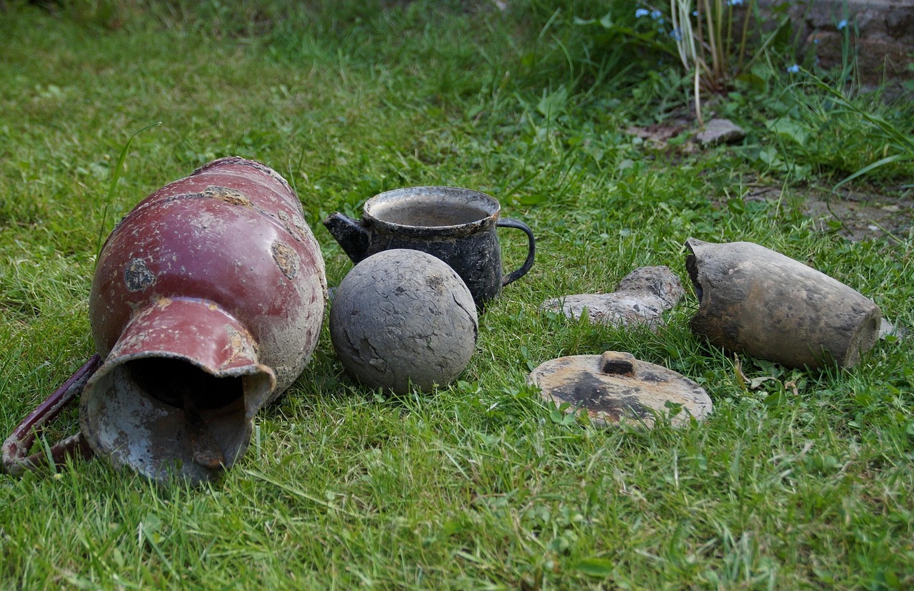 broken pots and other junk laying in grass