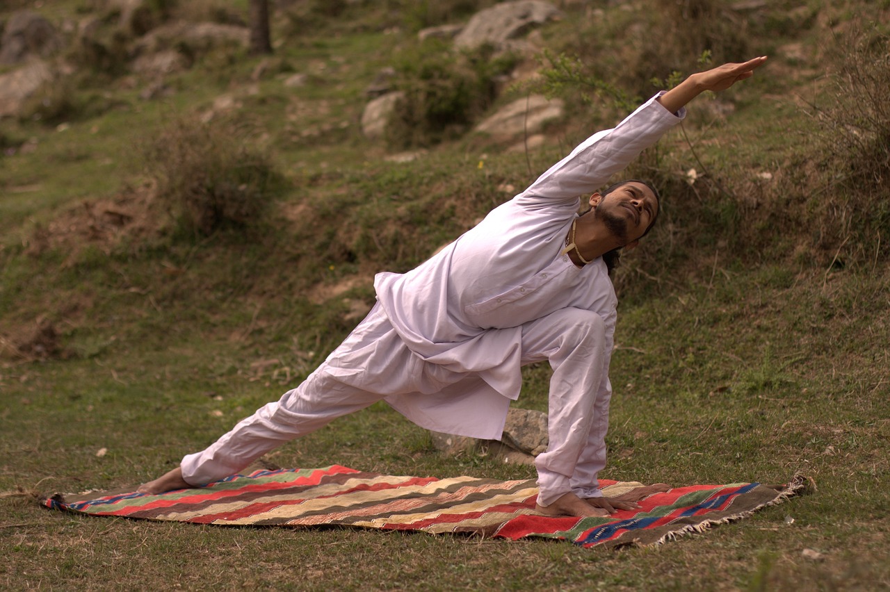 young indian yogi doing yoga at a park