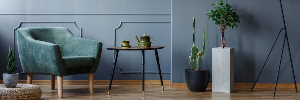 small tea table with tea set next to a green armchair