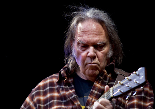 neil young playing guitar during his older years