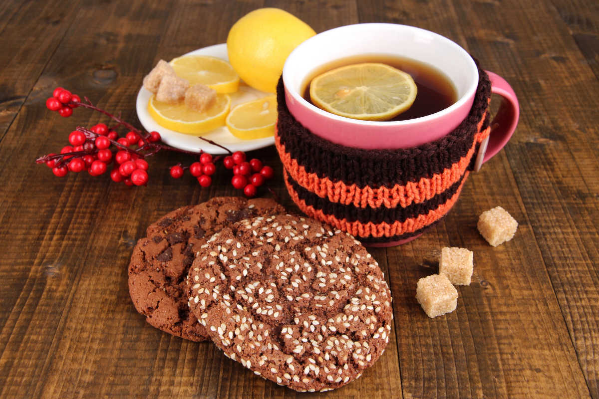cup of tea with tea cozy on a wooden table