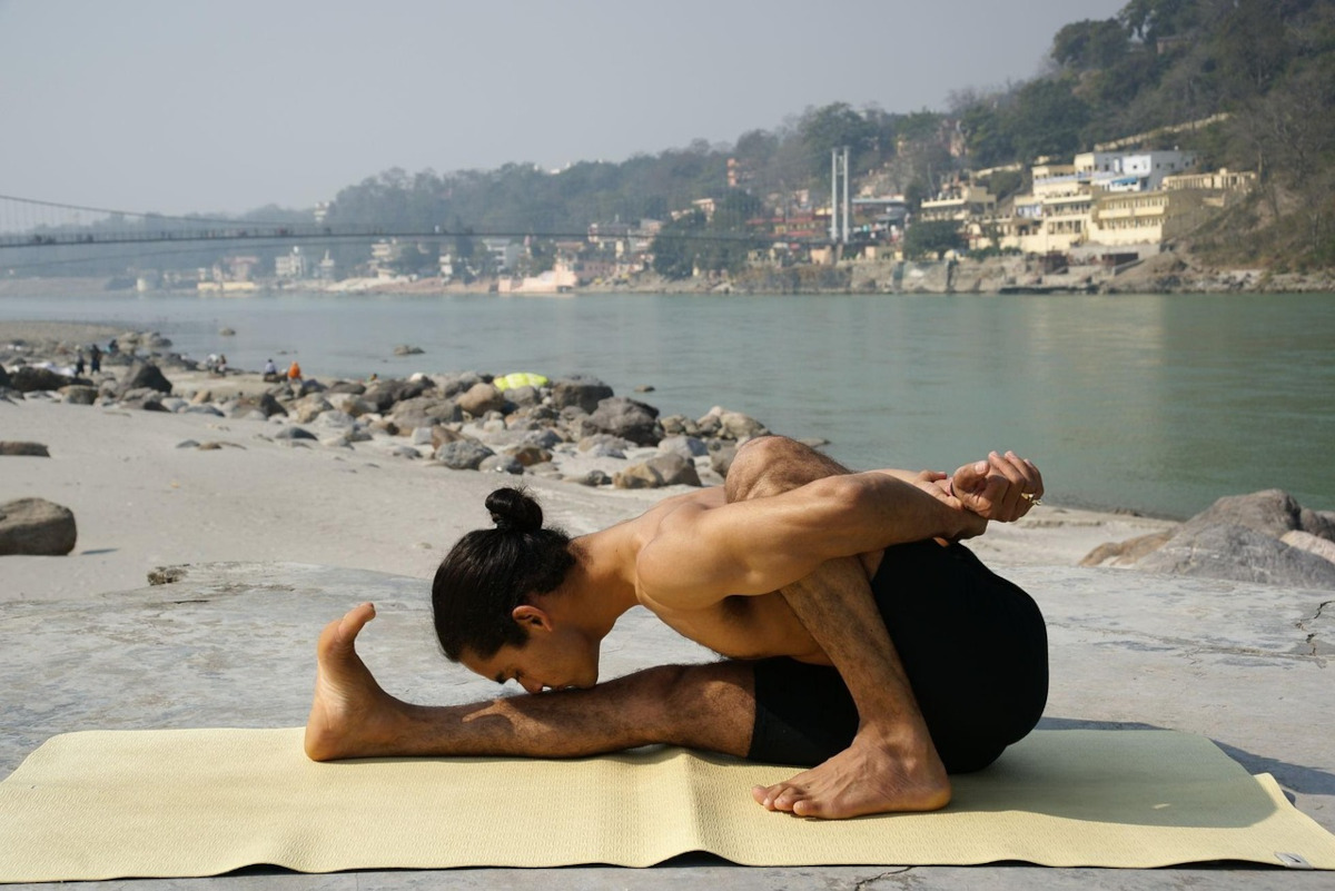 man practicing yoga on a mat outdoors