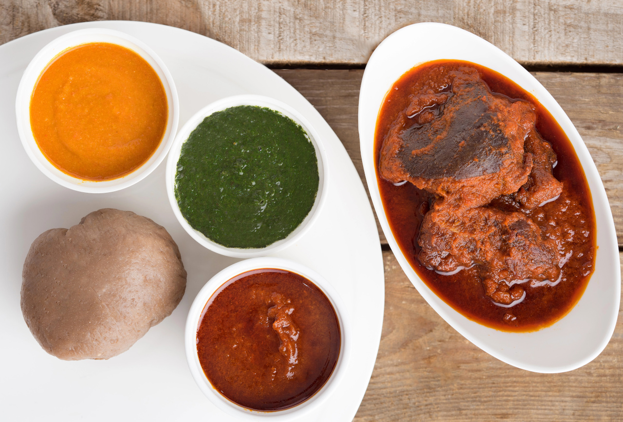 meal of Nigerian Amala, Ewedu and Gbegiri Soup Served with Goat Meat Stew in a white bowl