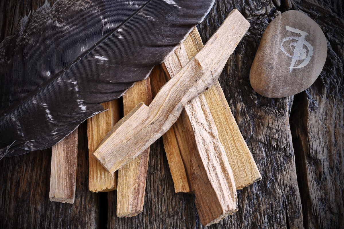 palo santo smudge sticks and a reiki healing symbol on a dark wooden table